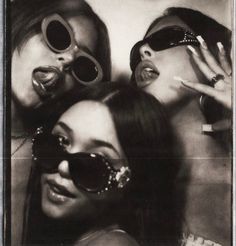 three women with sunglasses on their heads posing for the camera