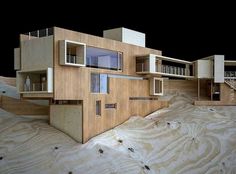 an architectural model of a house on top of sand dunes with stairs and balconies