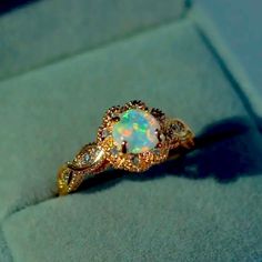 an opal and diamond ring in a box