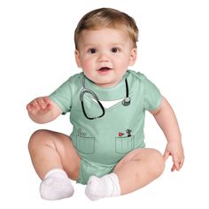 a baby sitting on the floor with a stethoscope around his neck and hands