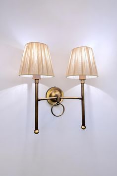 two lamps mounted on the wall next to each other with one light on it's side