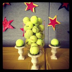 a vase filled with tennis balls sitting on top of a table next to star decorations