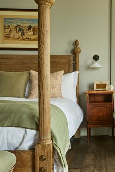 a bed sitting in a bedroom next to a wooden dresser and lamp on top of a hard wood floor