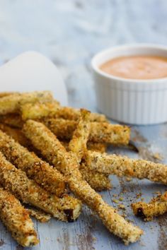 some fried food on a wooden table with dipping sauce