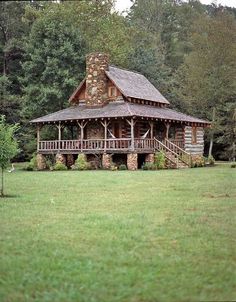 a log cabin sits in the middle of a field