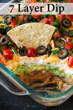 an enchilada dish with tortilla chips and black olives