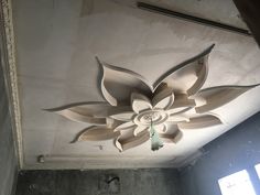 a ceiling fan is hanging from the ceiling in a room with concrete walls and windows