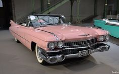 an old pink car is on display in a museum