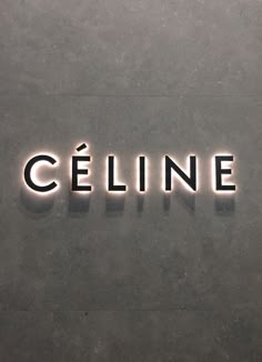 the word celline is lit up in front of a gray wall with black and white lettering