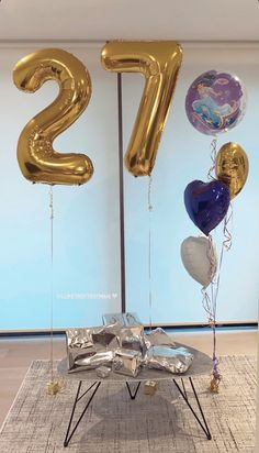 some balloons that are in the shape of numbers on a table with an iron stand