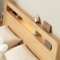 a wooden headboard with two alarm clocks on each side and an electronic clock mounted to the wall