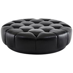 a black leather ottoman sitting on top of a white floor