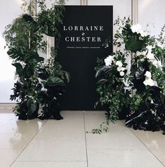 there are many plants in front of the black and white sign that says lorbaine chester