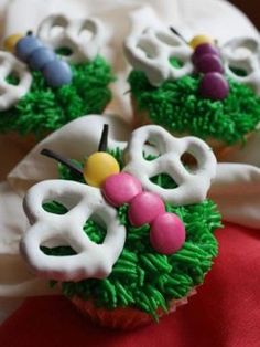 two cupcakes decorated with green and white icing, one is made to look like flowers