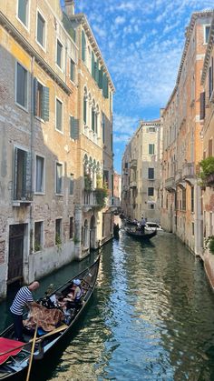 two gondola boats on a narrow canal in venice, italy with buildings lining both sides