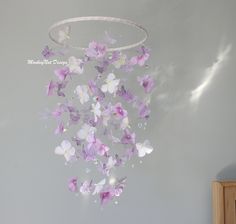 there are many purple and white butterflies hanging from the ceiling