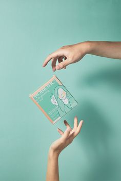 two hands reaching out towards each other holding a packet of face masks on a blue background