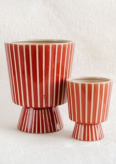 two red and white striped cups sitting next to each other