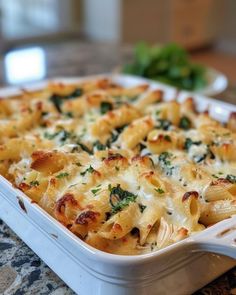 a casserole dish with cheese and spinach in it sitting on a table