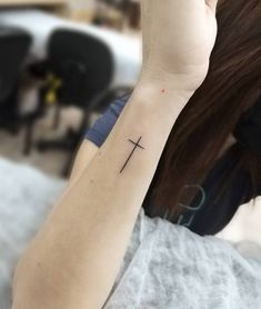 a woman with a cross tattoo on her arm