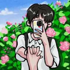 a man taking a selfie with his cell phone in front of some pink flowers