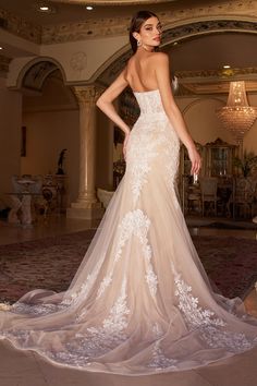 a woman in a wedding dress standing on the floor with her back to the camera