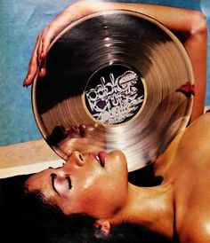 a woman laying on the ground with a record in her hand