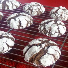 chocolate crinkle cookies cooling on a wire rack with powdered sugar in the middle