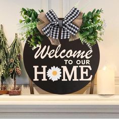 welcome to our home sign with flowers and greenery