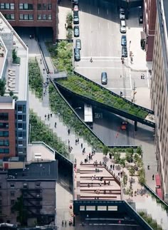 an aerial view of people walking on the sidewalk and cars driving down the street in front of tall buildings