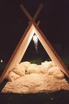 a bed that has been made into a teepee with pillows and blankets on it