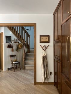 an open door leading to a living room with wooden floors and stairs in the background