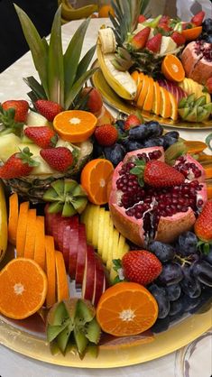 fruit platter with oranges, strawberries, grapes, bananas and pineapples