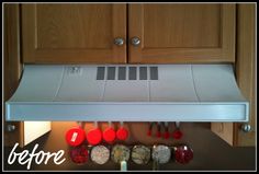 a range hood in a kitchen with utensils hanging from it