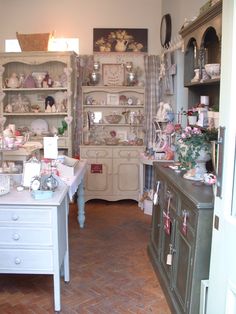 a room filled with lots of white furniture and shelves full of dishes on top of them