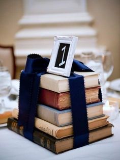 a stack of books on top of each other with a ribbon tied around the book