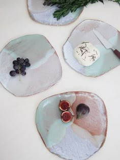 three plates with fruit on them sitting on a table