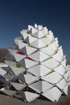 a large white sculpture sitting on top of a sandy beach