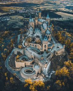 an aerial view of a castle in the middle of trees with yellow leaves on it