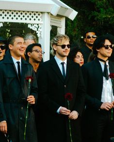 a group of men standing next to each other in front of a white gazebo