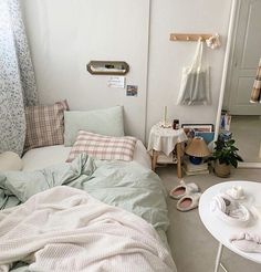 a bed room with a neatly made bed next to a table and chair in it