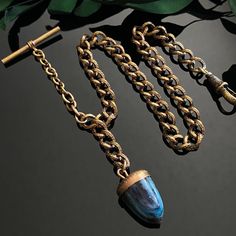 Antique gold filled chased link watch chain with blue (possibly Murano) art glass acorn fob. Chain includes t-bar and gold plated non-swivel dog clip.  Good condition with signs of age and wear including minor gold loss and crazing on the glass fob. Chain measures 12.5" from dog clip to t-bar Width 6.4mm Acron fob measures 19.5mm x 14mm Weighs 24.9 grams Murano Art, Antique Watch, Body Adornment, Dog Clip, Antique Watches, Victorian Gold, Watch Chain, Amulets, Blue Art