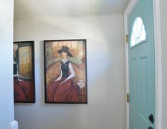 two paintings hang on the wall next to each other in front of a blue door