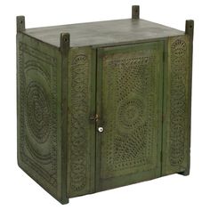 an old green cabinet with carvings on the front and sides, isolated against a white background