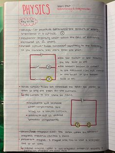 an open notebook with notes on physics and the text below it is written in red