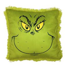 a green pillow with an angry grin face drawn on it's front and sides