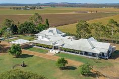 an aerial view of a large house in the middle of a field with lots of trees