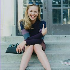 a woman sitting on the steps with her thumbs up