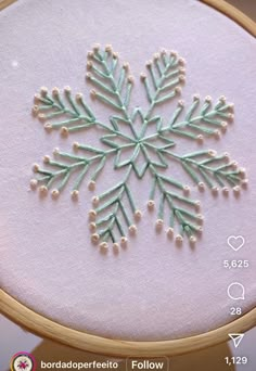 a cross stitch snowflake is shown in the hoop