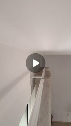 a video camera mounted to the side of a white wall next to a stair case